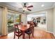 Cozy dining area with a ceiling fan and patio access that transitions to the living room with fireplace at 7197 S Newland St, Littleton, CO 80128