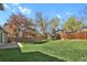 Expansive backyard featuring a well-kept lawn, mature trees, and a fenced perimeter for privacy at 8001 S Estes St, Littleton, CO 80128