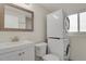 Cozy bathroom with stackable washer/dryer, white vanity, and ample natural light from the window at 8001 S Estes St, Littleton, CO 80128