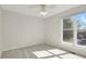 Empty bedroom includes neutral walls, neutral carpet, ceiling fan, and window allowing natural light to filter through at 8001 S Estes St, Littleton, CO 80128