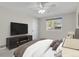 Staged bedroom with neutral walls, ceiling fan, and window allowing natural light to filter through at 8001 S Estes St, Littleton, CO 80128
