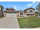 Well-maintained two-story home with brick and siding exterior and a green front lawn at 8001 S Estes St, Littleton, CO 80128