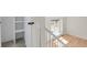 Bright hallway featuring hardwood floors, white trim, and a view of the staircase at 8001 S Estes St, Littleton, CO 80128