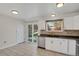 Bright kitchen featuring white cabinets, tile backsplash, stainless steel appliances, and sliding patio door at 8001 S Estes St, Littleton, CO 80128