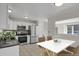 Staged kitchen with white cabinets, dining area, stainless steel appliances and pass-through to the living room at 8001 S Estes St, Littleton, CO 80128