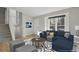 Staged living room with a cozy blue couch, stairs to the second level, and large window at 8001 S Estes St, Littleton, CO 80128
