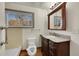 Bathroom featuring a classic vanity with granite countertop, a toilet, and a shower, lit by a window at 2015 Elmira St, Aurora, CO 80010