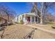 Charming single-story home with a covered front porch and classic design details, set against a clear blue sky at 2015 Elmira St, Aurora, CO 80010