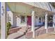 View of the home's porch with columns, featuring decorative details and a colorful front door at 2015 Elmira St, Aurora, CO 80010