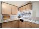 Compact kitchen featuring wood cabinets, laminate countertops, and basic appliances at 2015 Elmira St, Aurora, CO 80010