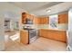 Well-lit kitchen with stainless steel appliances, light wood cabinets, and a view into the living area at 2015 Elmira St, Aurora, CO 80010