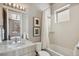 Bright bathroom featuring a shower over tub, and stylish fixtures including a grey vanity with white marble top at 1012 Bannock St, Denver, CO 80204