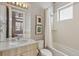 Bright bathroom with a marble countertop vanity, tub and shower combo, and neutral walls at 1012 Bannock St, Denver, CO 80204