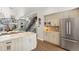 Open kitchen and dining area with stainless steel refrigerator and light wood cabinets leading into the living room and staircase at 1012 Bannock St, Denver, CO 80204
