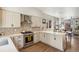 Bright, open-concept kitchen with light wood cabinetry, stainless steel appliances, stone counters, and hardwood floors at 1012 Bannock St, Denver, CO 80204