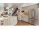 Bright kitchen with stainless steel appliances, white cabinets, island and hardwood floors at 1012 Bannock St, Denver, CO 80204