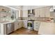 Well-lit kitchen featuring light wood cabinets, stainless steel appliances, and decorative backsplash with a view to the outside at 1012 Bannock St, Denver, CO 80204