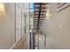 Modern staircase with wood treads and metal railing, illuminated by a tall window offering city views at 1012 Bannock St, Denver, CO 80204