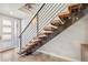Modern staircase with open wooden treads and iron railings, adjacent to a bright white entry door at 1012 Bannock St, Denver, CO 80204