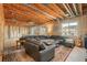 Unfinished basement featuring exposed ceiling, carpeted lounge area with large leather sofa set, and ample natural light from large windows at 5900 Haywagon Ln, Castle Rock, CO 80108