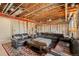 Unfinished basement showcasing exposed ceiling, red support beam, and cozy lounge area with sofas, ottoman and decorative rug at 5900 Haywagon Ln, Castle Rock, CO 80108