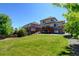 Spacious backyard featuring a well-kept lawn, stone accents, and tasteful landscaping at 7081 S Oak Hill Cir, Aurora, CO 80016