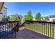 Spacious wooden deck with a blue bench and railing overlooking the community at 7081 S Oak Hill Cir, Aurora, CO 80016