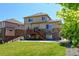Two-story home with a wooden deck, a well-kept lawn, and stone accents at 7081 S Oak Hill Cir, Aurora, CO 80016