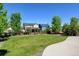 Wide backyard with green grass, fence and trees surrounding the yard at 7081 S Oak Hill Cir, Aurora, CO 80016