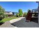 Backyard with a concrete patio, stairs to the deck, green grass and gravel at 7081 S Oak Hill Cir, Aurora, CO 80016