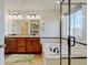 Bright bathroom with double sink vanity, large mirror, soaking tub, and glass enclosed shower at 7081 S Oak Hill Cir, Aurora, CO 80016