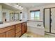 Relaxing bathroom featuring dual sinks, soaking tub, walk-in shower and large window at 7081 S Oak Hill Cir, Aurora, CO 80016
