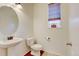 Charming powder room boasts decorative mirror, single sink vanity, and natural light from window at 7081 S Oak Hill Cir, Aurora, CO 80016