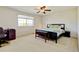 Cozy carpeted bedroom features ceiling fan, large window for natural light, and furniture at 7081 S Oak Hill Cir, Aurora, CO 80016