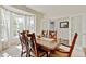 Sunlit dining room showcasing a large wooden table, chairs, and bay windows at 7081 S Oak Hill Cir, Aurora, CO 80016