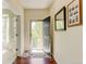 Bright foyer with hardwood floors, featuring an open front door and decorative rug at 7081 S Oak Hill Cir, Aurora, CO 80016