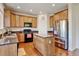 Well-lit kitchen features granite countertops, an island, stainless steel refrigerator and wood cabinets at 7081 S Oak Hill Cir, Aurora, CO 80016