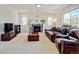 Inviting living room with a cozy fireplace, large windows, and comfortable leather seating at 7081 S Oak Hill Cir, Aurora, CO 80016
