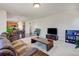 Open-concept living area with a large sofa, TV area and view of the kitchen at 7081 S Oak Hill Cir, Aurora, CO 80016