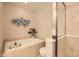 Relaxing bathroom featuring a soaking tub with tiled surround and glass-enclosed shower at 3411 N Xenia St, Denver, CO 80238