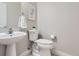 Clean half bathroom with a pedestal sink, white toilet, and modern decor at 3411 N Xenia St, Denver, CO 80238