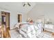 Bright bedroom featuring a vaulted ceiling, plush bedding, hardwood floors, and ample natural light at 3411 N Xenia St, Denver, CO 80238