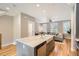 Open kitchen featuring an island with a farmhouse sink, stainless steel appliances, and hardwood floors at 3411 N Xenia St, Denver, CO 80238