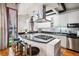 Modern kitchen with stainless steel appliances, black countertops, and a breakfast bar with stools at 1020 15Th St # 214, Denver, CO 80202