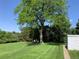 Well-maintained backyard with a lush lawn, mature tree, and convenient storage shed at 2797 S Newton Way, Denver, CO 80236
