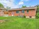 A well-maintained backyard with a brick house and lush lawn, perfect for outdoor enjoyment at 2797 S Newton Way, Denver, CO 80236