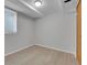 A simple room in the basement with vinyl floors, windows with blinds, and overhead lighting at 2797 S Newton Way, Denver, CO 80236