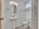 Updated bathroom features a pedestal sink, modern fixtures, updated toilet and shower with decorative accent tile at 2797 S Newton Way, Denver, CO 80236