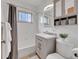 Well-lit bathroom featuring vanity and neutral wall-mounted storage and a shower at 2797 S Newton Way, Denver, CO 80236