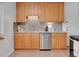 Cozy kitchen featuring stainless steel appliances and warm wood cabinets at 2797 S Newton Way, Denver, CO 80236